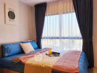 Cozy bedroom with large window and stylish decor, offering a serene and inviting atmosphere.