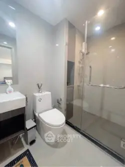 Modern bathroom with glass shower and sleek fixtures in a contemporary apartment.