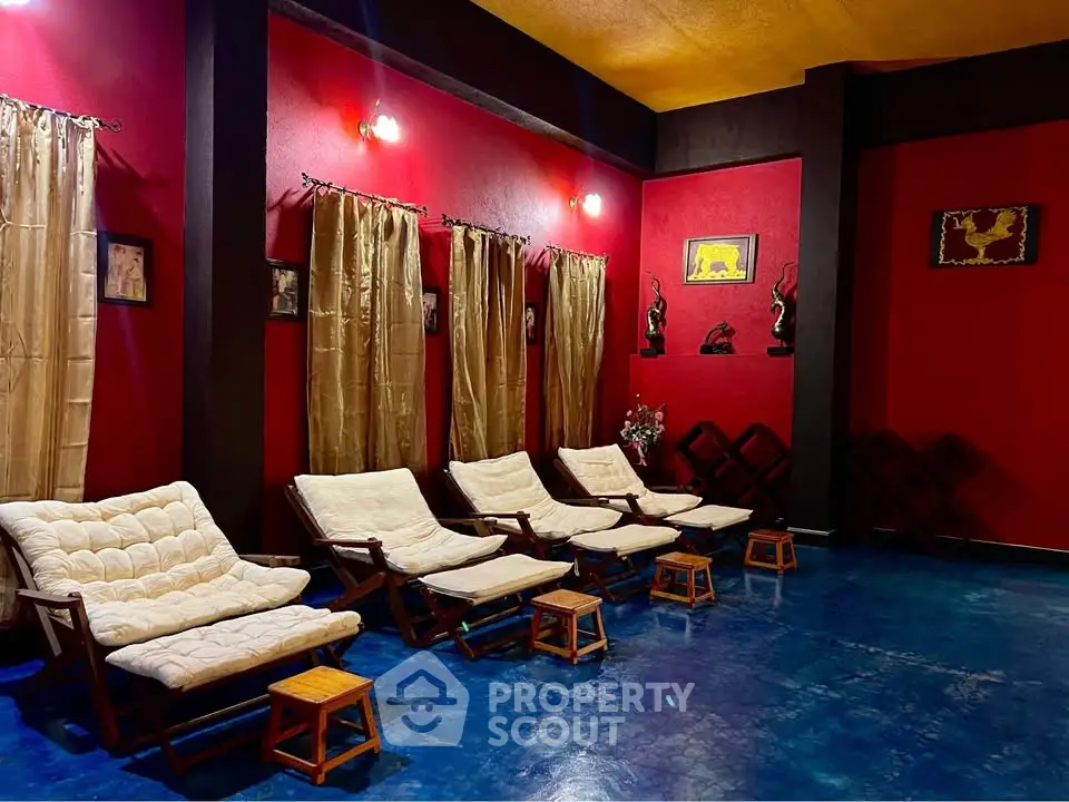 Luxurious lounge area with vibrant red walls and comfortable seating, perfect for relaxation.