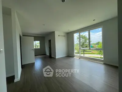 Spacious empty room with large windows and natural light, perfect for customization.