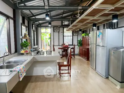 Spacious kitchen with modern appliances and dining area, featuring open layout and natural light.