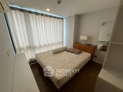 Cozy bedroom with natural light, featuring a comfortable bed and modern furnishings, ideal for relaxation.
