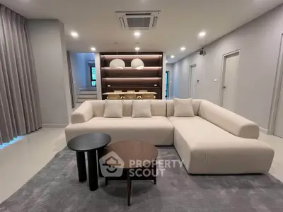 Spacious modern living room with elegant furniture and stylish lighting, perfect for relaxation and entertainment.