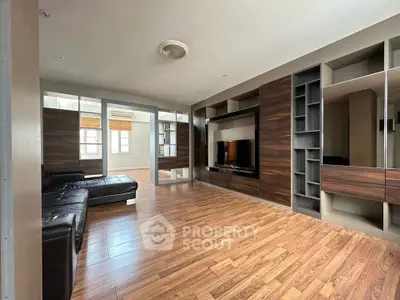 Spacious living room with modern wood flooring and built-in entertainment center.