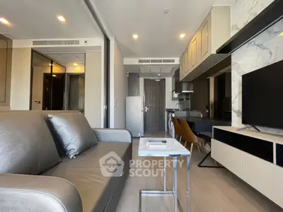 Modern living room with sleek furniture and open kitchen layout in a stylish apartment.