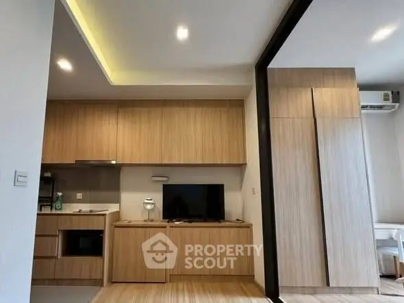 Modern living room with sleek wooden cabinetry and integrated TV unit