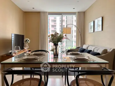 Modern living room with elegant dining setup and large window view.