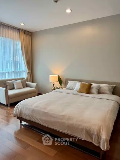 Spacious bedroom with elegant decor and natural light in modern apartment.