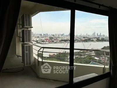 Stunning cityscape view from high-rise balcony overlooking river and skyline.
