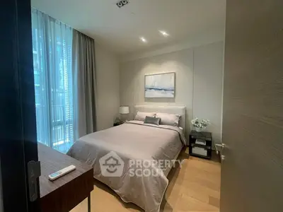 Modern bedroom with elegant decor and natural light, featuring a cozy bed and stylish furnishings.
