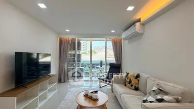 Modern living room with large windows and stylish furniture, perfect for relaxation and entertainment.
