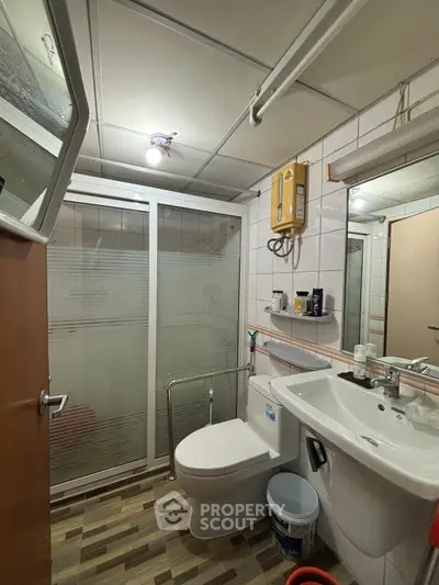 Modern bathroom with shower enclosure and sleek fixtures in a contemporary apartment.