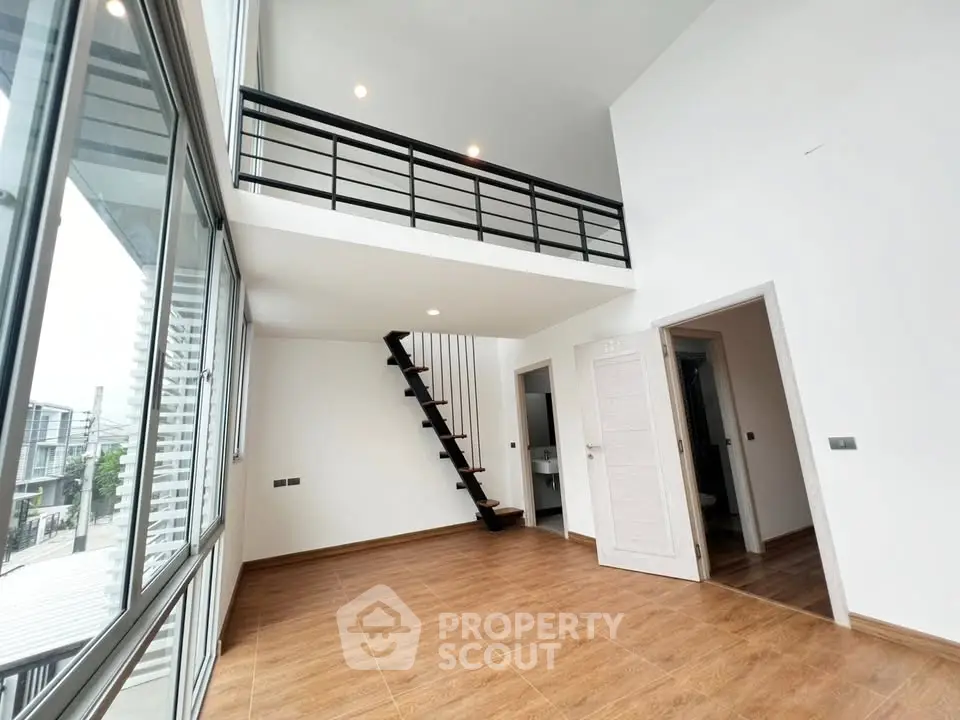 Spacious modern loft with high ceilings and mezzanine in a bright, open living area.