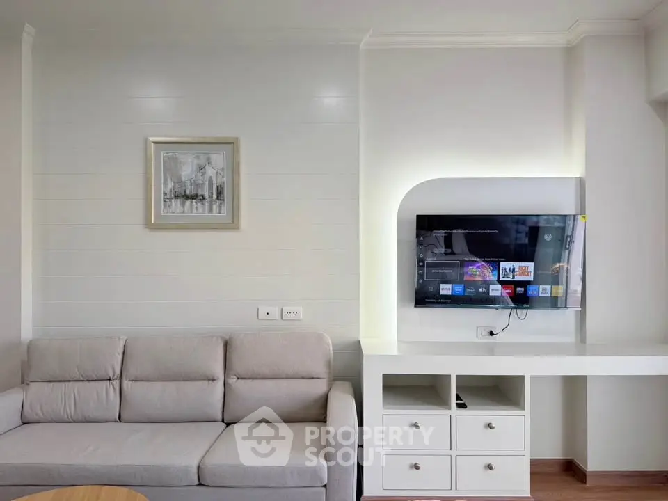 Modern living room with sleek TV setup and comfortable sofa in stylish apartment.