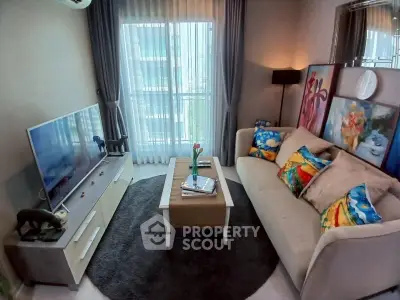 Cozy living room with modern decor, large TV, and vibrant artwork, perfect for relaxation and entertainment.