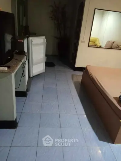 Cozy living space with open fridge and comfortable seating area.