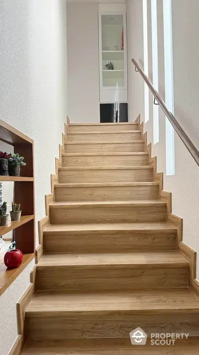 Modern wooden staircase with built-in shelving and natural light