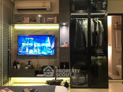 Modern bedroom with sleek storage and ambient lighting, featuring a wall-mounted TV and stylish decor.