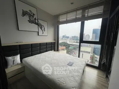 Modern bedroom with large window offering stunning city view, stylish decor, and natural light.