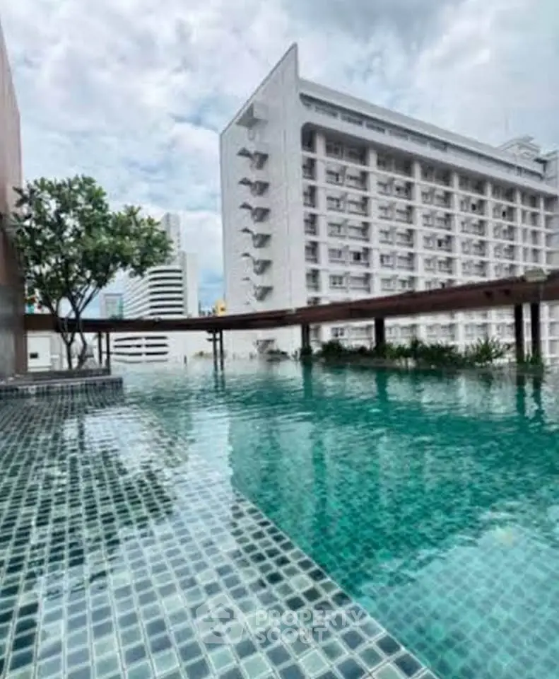Luxurious rooftop pool with stunning cityscape views in modern urban building.