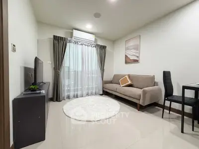 Modern living room with cozy sofa, TV, and stylish decor in a bright apartment.