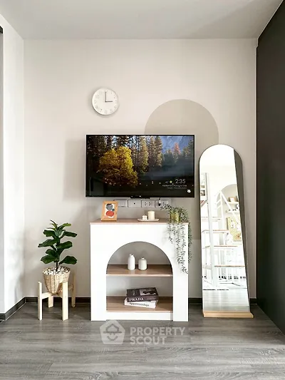 Modern living room with stylish decor, wall-mounted TV, and elegant mirror.