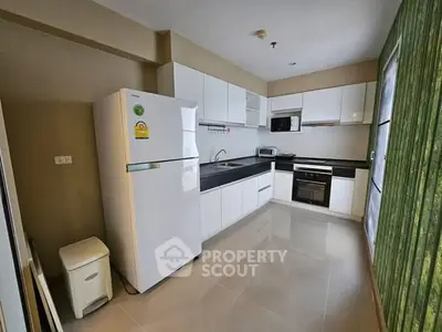 Modern kitchen with sleek white cabinets, stainless steel appliances, and spacious layout.