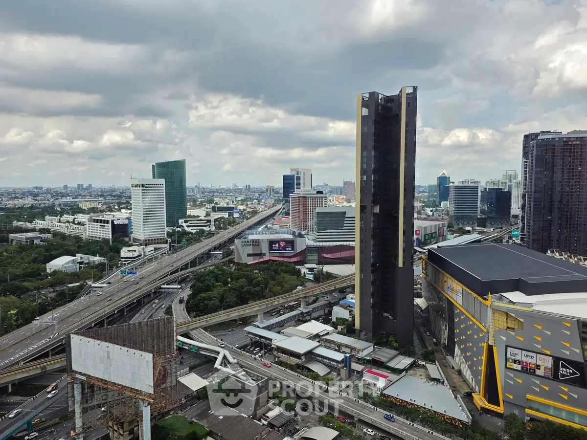 Stunning cityscape view showcasing modern skyscrapers and bustling highways under a dramatic cloudy sky.