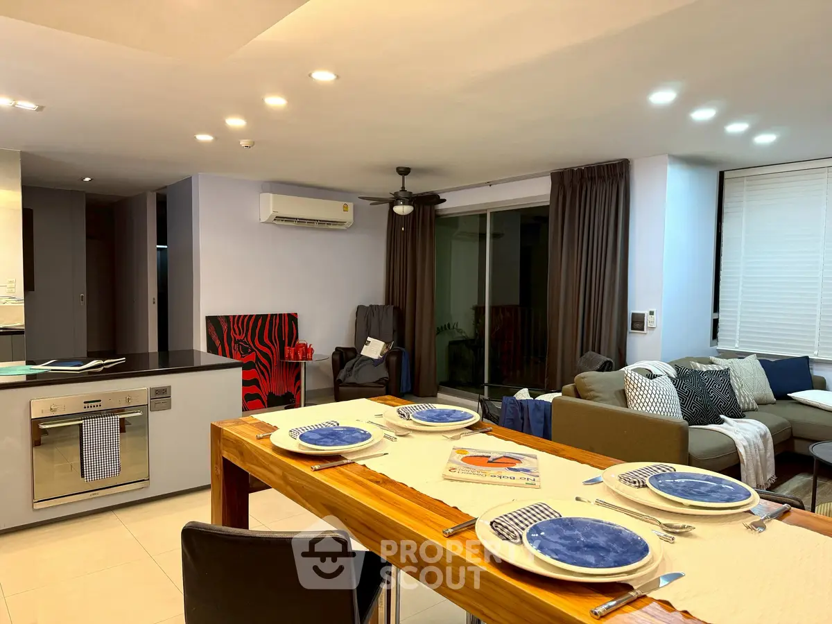 Modern open-plan living and dining area with stylish decor and natural lighting.