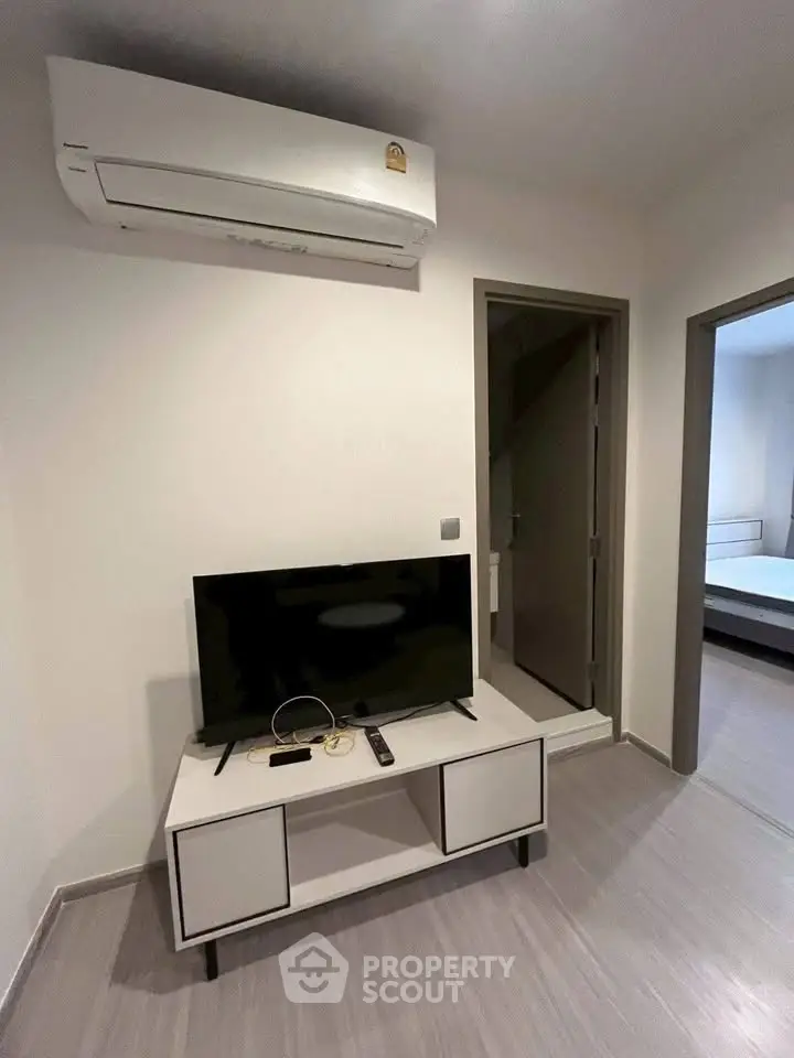 Modern living room with sleek TV setup and air conditioning unit