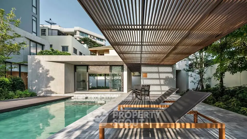 Luxurious modern home with sleek poolside lounge area and stylish pergola.