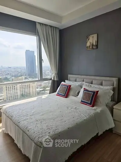 Modern bedroom with stunning city view and elegant decor in high-rise apartment.