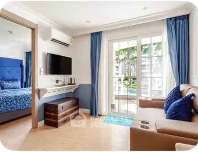 Charming living room with cozy seating, TV, and balcony access in a stylish apartment.