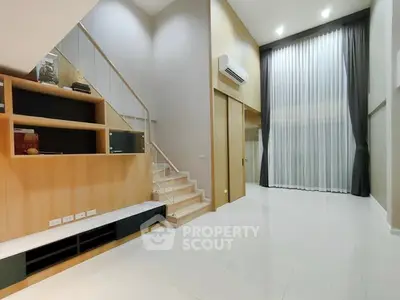 Spacious modern living room with high ceilings and elegant staircase