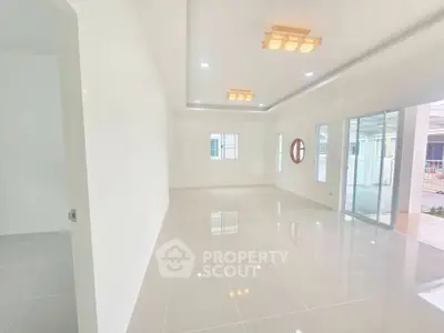 Spacious modern living room with large windows and elegant lighting fixtures.