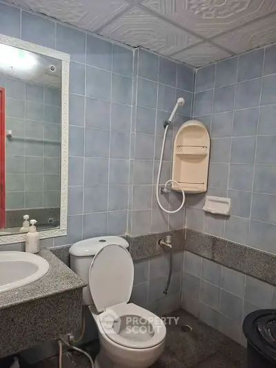 Functional bathroom with modern fixtures and tiled walls in a real estate property.