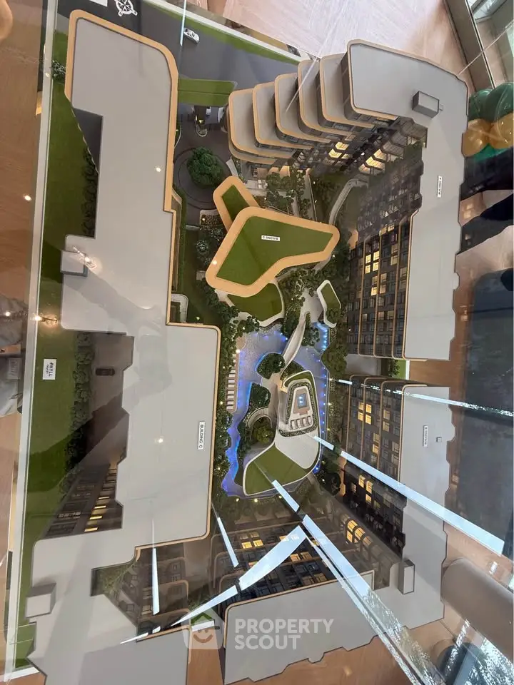 Top view of modern architectural model showcasing luxury residential complex with lush gardens and pool.