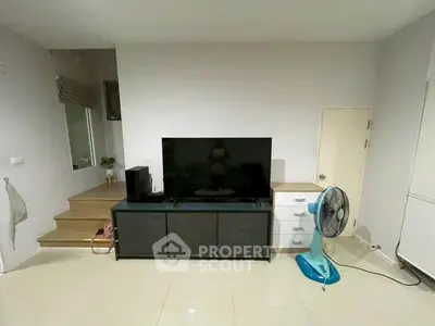Modern living room with sleek TV stand and fan, minimalist design