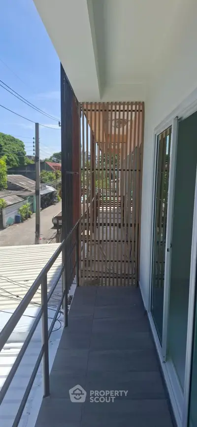 Modern balcony with sleek railing and wooden privacy screen