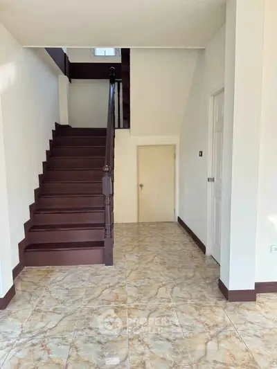 Spacious interior with elegant staircase and marble flooring