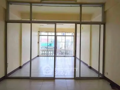 Spacious empty room with large glass doors and bright natural light