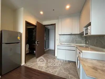 Modern kitchen with sleek appliances and marble countertops in a stylish apartment.