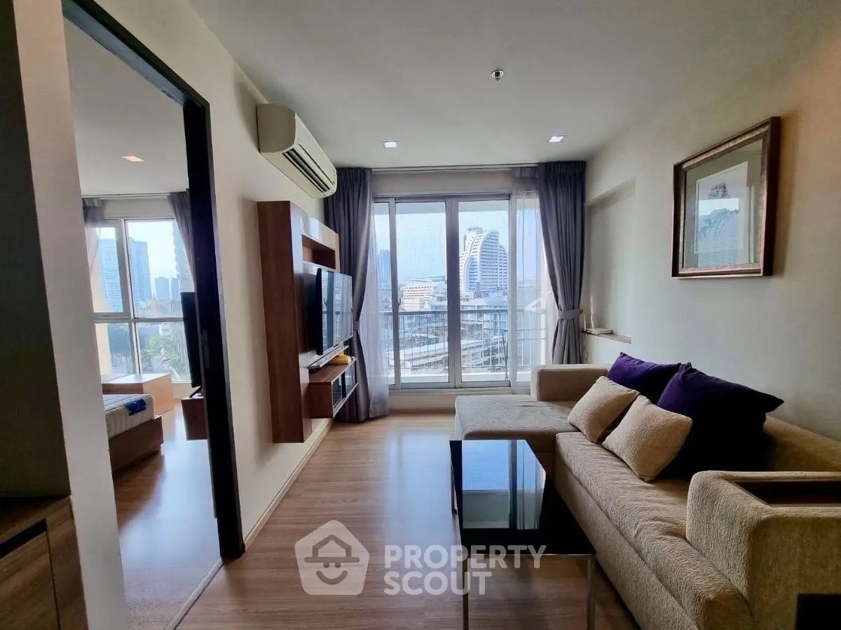 Modern living room with city view, featuring a cozy sofa and sleek TV setup.