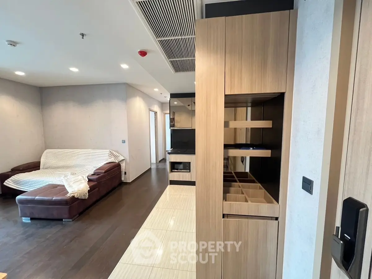 Modern living room with stylish wooden cabinetry and cozy seating area.