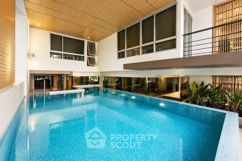 Luxurious indoor pool with modern design and large windows in upscale property.