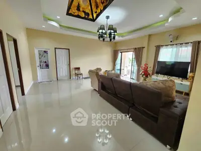 Spacious living room with elegant chandelier and large windows for natural light.
