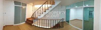 Spacious modern interior with wooden flooring and elegant staircase, perfect for stylish living.