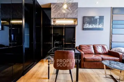 Modern living room with sleek black cabinetry, leather sofa, and stylish lighting