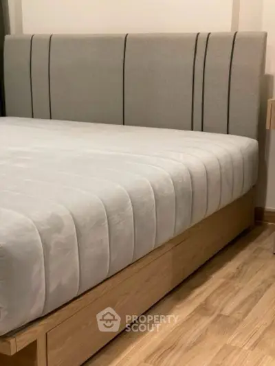 Modern bedroom with stylish bed and wooden flooring, perfect for a cozy retreat.