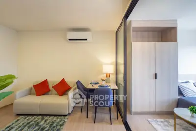 Modern living room with cozy sofa, dining area, and stylish decor in a compact apartment.